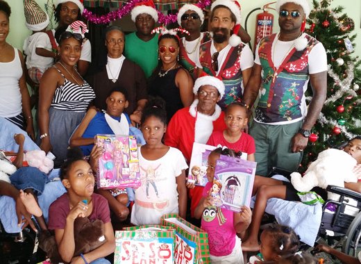 The Get Nice Crew, pose with staff and children at St. Benedicts Day Nursery and Childrens Home in Georgetown.