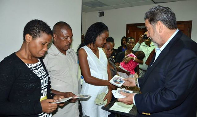 Prime Minister Gonsalves presents CD to relatives of victims of the tragedy on Tuesday. (Photo: Lance Neverson/Facebook)