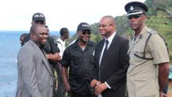 Director of the FIU, Grenville Williams, second right, chat with police officers on the sidelines of a funeral in Fancy on Sunday. (IWN photo)