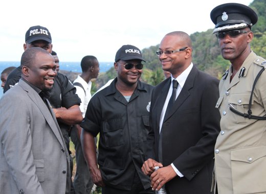 Director of the FIU, Grenville Williams, second right, chat with police officers on the sidelines of a funeral in Fancy on Sunday. (IWN photo)