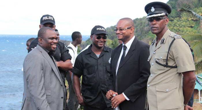 Director of the FIU, Grenville Williams, second right, chat with police officers on the sidelines of a funeral in Fancy on Sunday. (IWN photo)