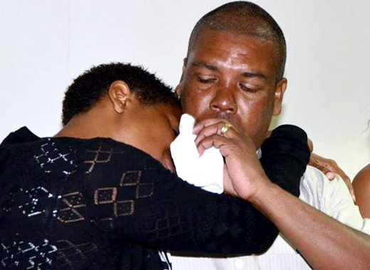 Station Sergeant of Police Hezron Ballantyne, whose daughter is missing at sea, consoles another parent during the launch of the CD on Tuesday. (Photo: Lance Neverson/Facebook)