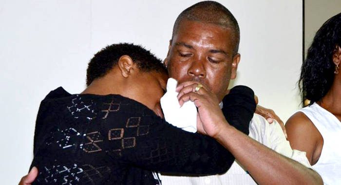 Station Sergeant of Police Hezron Ballantyne, whose daughter is missing at sea, consoles another parent during the launch of the CD on Tuesday. (Photo: Lance Neverson/Facebook)