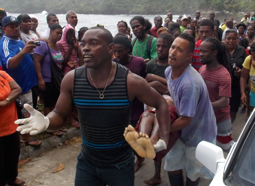 Men carry the body of a female studentsafter it was recovered from the sea on Monday. (IWN photo)