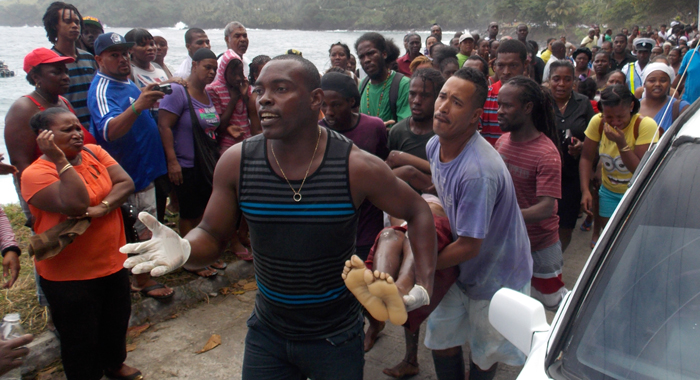 Men carry the body of a female studentsafter it was recovered from the sea on Monday. (IWN photo)
