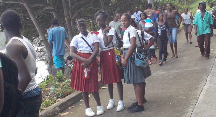 Secondary school students and other onlookers at the scene in Rock Gutter on Monday. (IWN photo)
