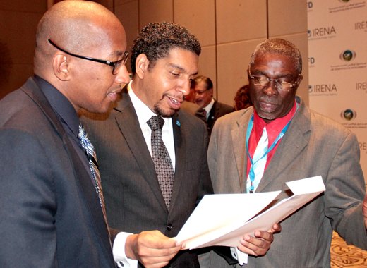 From left: Ellsworth Dacon, Sen. Camillo Gonsalves, and Hon. Clayton Burgin peruse a document after the announcement in Abu Dhabi on Sunday. (Photo: CMC/IWN)