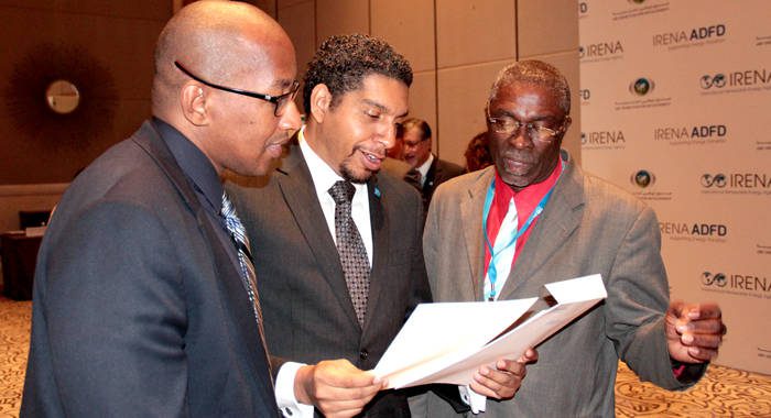 From left: Ellsworth Dacon, Sen. Camillo Gonsalves, and Hon. Clayton Burgin peruse a document after the announcement in Abu Dhabi on Sunday. (Photo: CMC/IWN)
