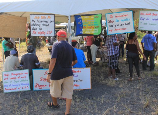 Businessman Leon "Bigger Bigs" Samuel on saturday displays the placards he used in his bid to get his mining licence back. (IWN photo)