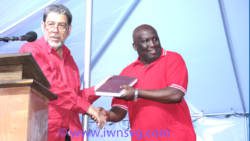 PM Dr. Ralph Gonsalves presents a book to Jimmy Prince, who is tipped to be the ULP's candidate in Marriaqua. (IWN photo)