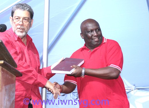 PM Dr. Ralph Gonsalves presents a book to Jimmy Prince, who is tipped to be the ULP's candidate in Marriaqua. (IWN photo)