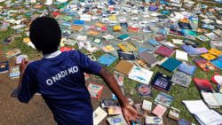 A boy runs past books drying in the sun on March 18, 2015 after the roof of the Central School library, in Port Vila, the capital city of Vanuatu, was blown away by Cyclone Pam. (Photo: Edgar Su/Reuters)