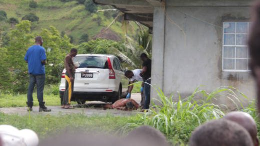 Police look on as a physician examines the body of King Collingford Mattis outside his house in Vermont on Saturday. (WN photo)