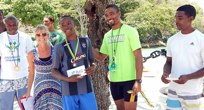 From left: Coach Kara Randall, swimmer Tyrell Raguette receiving third prize and Coach Tauran Ollivierre.