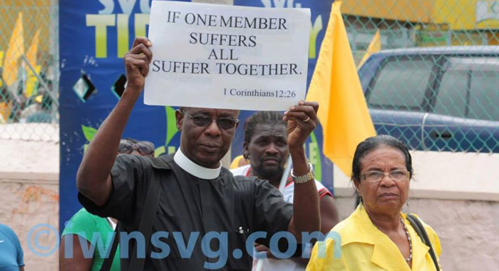 Rev. Ulric Jones and other persons take part in a protest march organised by the opposition New Democratic Party in Kingstown in July 2013. (IWN photo)