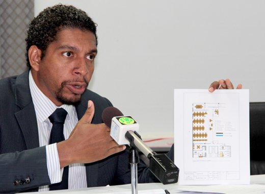Minister of Technology Sen. Camillo Gonsalves holds up the floor plan of the call centre that Digicel will open in SVG.  (IWN photo)