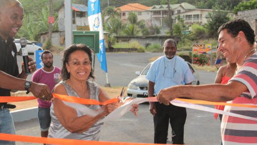 Martello Knights, left, assist his mother in cutting the ribbon at the rebranded Sol service station. (IWN Photo)
