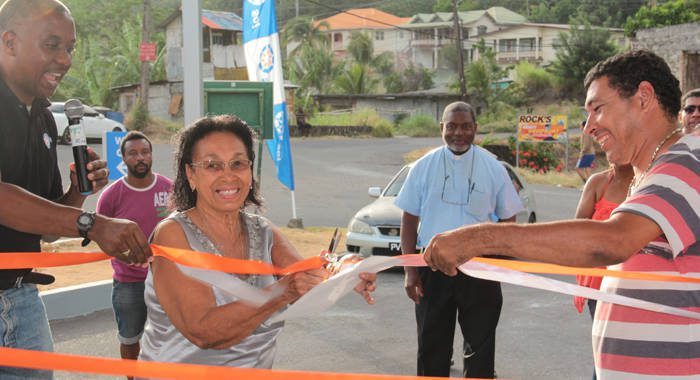 Martello Knights, left, assist his mother in cutting the ribbon at the rebranded Sol service station. (IWN Photo)
