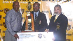 Inspector Hawkins Nanton, centre, receiving his award from Trinidad and Tobago Acting Commissioner of Police Stephen Williams, left, and Michael Aboud.
