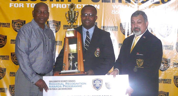 Inspector Hawkins Nanton, centre, receiving his award from Trinidad and Tobago Acting Commissioner of Police Stephen Williams, left, and Michael Aboud.