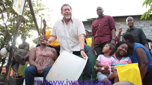 PM Dr. Ralph Gonsalves beats a "drum" and shouts "Labour" in Fitz Hughes on Friday as protestors and his bodyguards look on. (Photo: Zavique Morris-Chance/IWN)