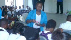 Police Constable Karla Timm distributing crime tips brochures to students of the Sandy Bay Secondary School.