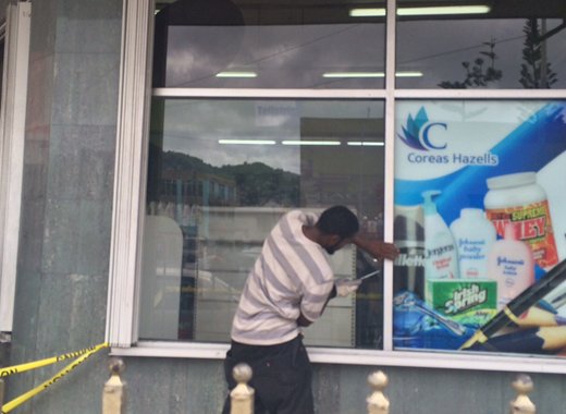 A man replaces the damaged window at Coreas City store on Tuesday. (IWN photo)