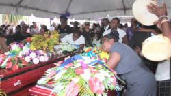Mourners sing and dance around the caskets in Spring Village on Sunday. (IWN photo)