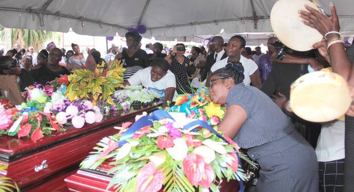 Mourners sing and dance around the caskets in Spring Village on Sunday. (IWN photo)