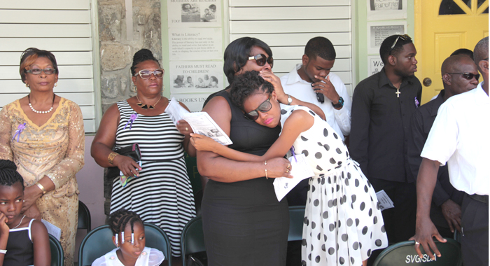 Women comfort each other at the funeral in Spring Village on Sunday. (IWN photo)