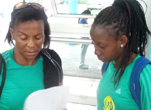 Coach Andrea Davis-Latchman, left, and Shantel Williams go through some last minute details at ET. Joshua Airport. (Photo: E. Glenford Prescott)