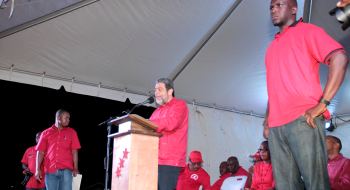Police officers dressed in red, flanks Prime Minister Ralph Gonsalves as he address a ULP rally in Redemption Sharpes Sunday night. (IWN photo)