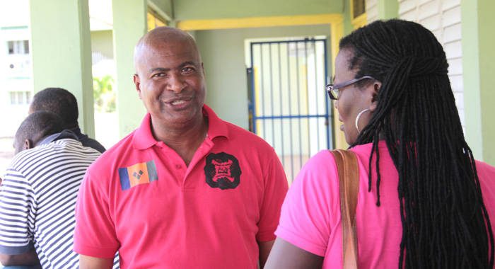 President of the Teachers' Union, Oswald Robinson, speaks with a union member after a meeting in September 2015. (IWN photo)