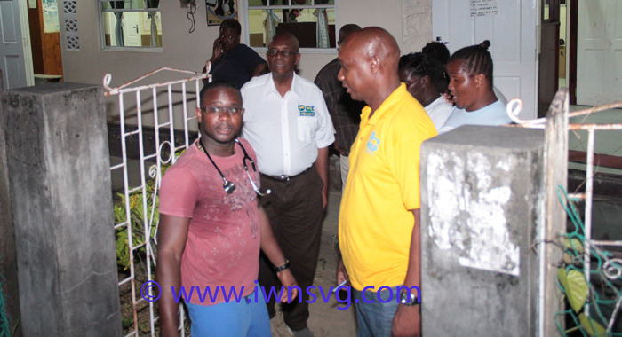 District Medical Officer, Dr. Francis Murray, left, Opposition Leader ARnhim Eustace, and NDP North Windward candidate, Lauron Baptiste, and other persons outside the Spring Village Health Centre, where the injured who were initially treated. (IWN photo)