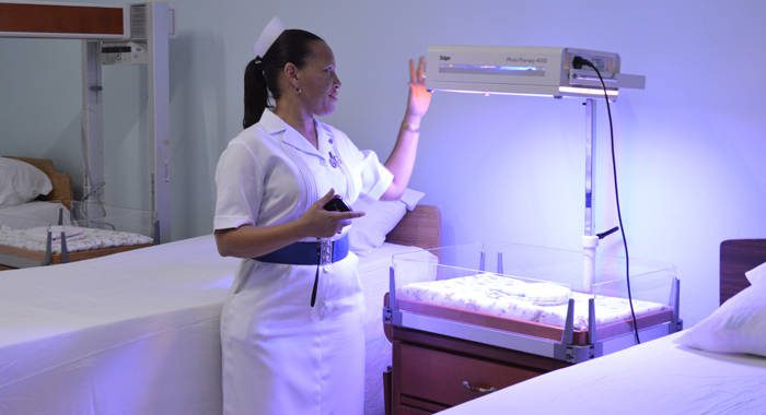 Mothers in the Northern Grenadines can now deliver their babies at the Bequia Hospital, upgraded through the CDB's Basic Needs Trust Fund. In this photo, Nurse Hutchinson shows how the ultraviolet light in the maternity ward works.