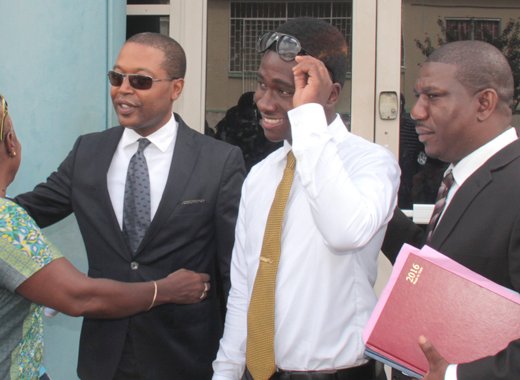 Ben Exeter, second left, and Shabazaah GunMunro George, along with their lawyer, Israel Bruce out side the Kingstown Magistrate Court on Wednesday. (IWN photo)