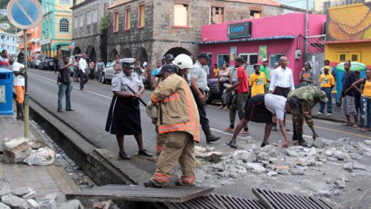 Police officers and fire fighters remove debris dumped in the street of Kingstown by NDP protesters on Monday. (IWN photo) 