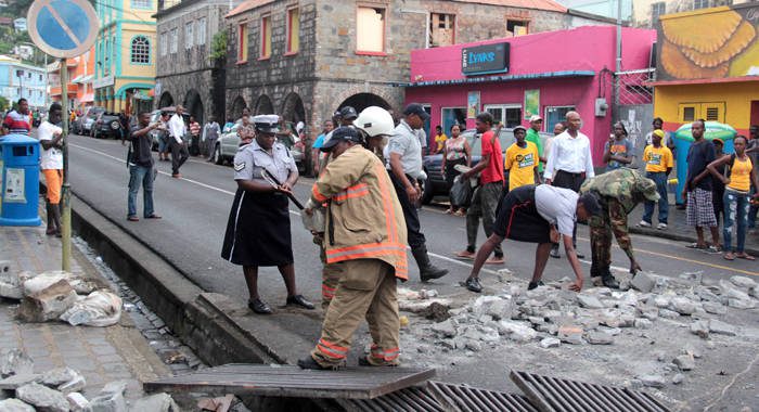 Police officers and fire fighters remove debris dumped in the street of Kingstown by NDP protesters on Monday. (IWN photo) 