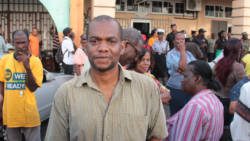 Grenadian journalist, Hamlet Mark, returns to report on the protest after being released from police custody Thursday afternoon. (IWN photo)