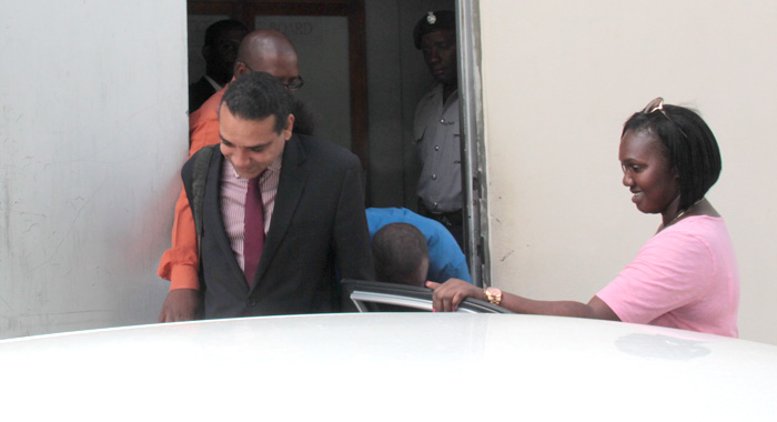 John, in blue, hides behind his lawyer, Ronnie Marks, as he exits the court building. (IWN photo)