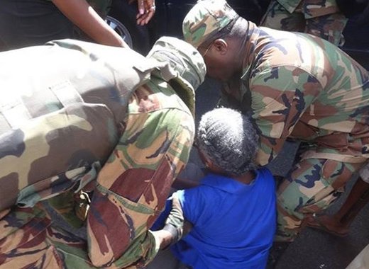 Police remove activist Luzette King from in front the Electoral Office on Wednesday. (IWN photo)