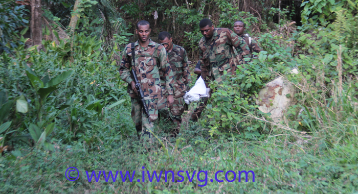 Police and funeral home workers return from the mountains with the second of the two bodies. (IWN photo)