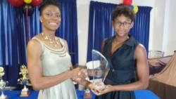 Kineke Alexander, left, collects award from Shné Joachim.
