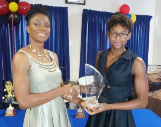 Kineke Alexander, left, collects award from Shné Joachim.