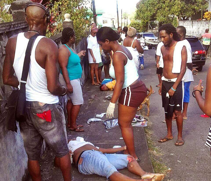 Persons assists the injured pedestrians at the scene of the accident.