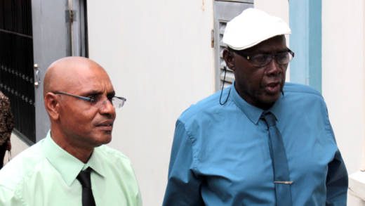 School principal Colbert Bowens, left, was Wednesday freed of a charge in connection with the death of seven students. He chats with Pastor Ehud Myers, who is still before court on the same matter.  (IWN photo)