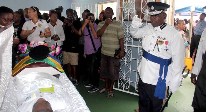 Commissioner of Police Michael Charles pays his respects to slain officer Police Constable Giovanni Charles at his funeral in Kingstown on Saturday. (IWN photo)