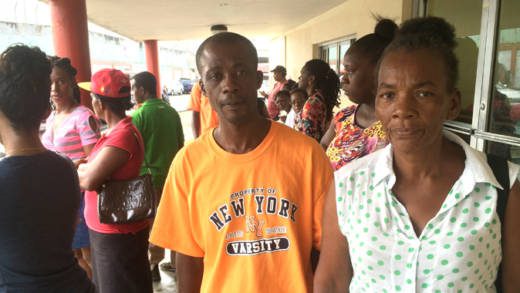 Bernise Bowens, common-law wife of injured man, Picton Pierre, along with his brother and other relatives outside MCMH on Thursday morning. (IWN photo)