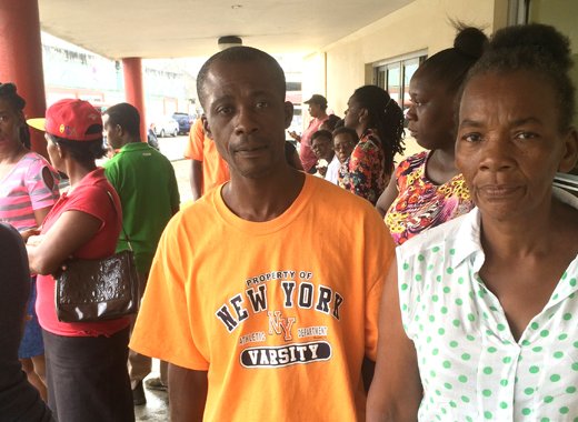 Bernise Bowens, common-law wife of injured man, Picton Pierre, along with his brother and other relatives outside MCMH on Thursday morning. (IWN photo)