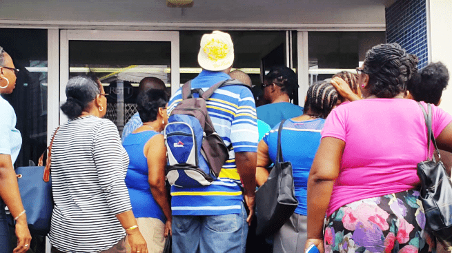Persons wait to go into RBTT Bank on Wednesday. (Photo: Jerry S. George).